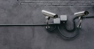 two bullet surveillance cameras attached on wall